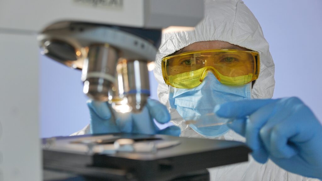 photo of a microscope and a lab scientist