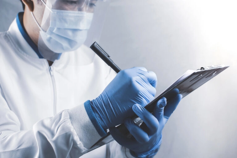 A water quality inspector taking notes while sampling water