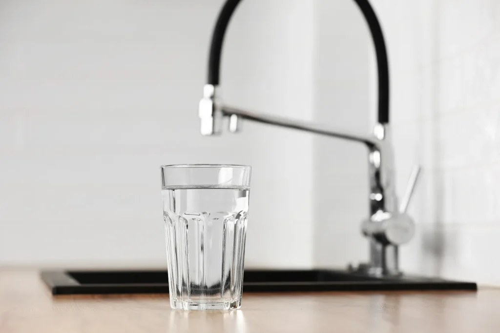 Transparent Glass Of Clean Filtering Water On Wooden Table in the kitchen