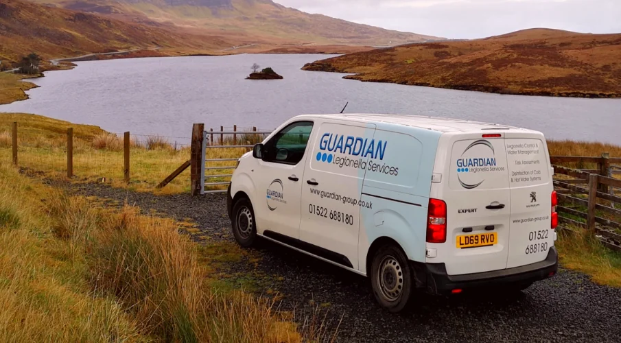 A picture of a Guardian Group Legionella Service work van parked next to a large reservoir